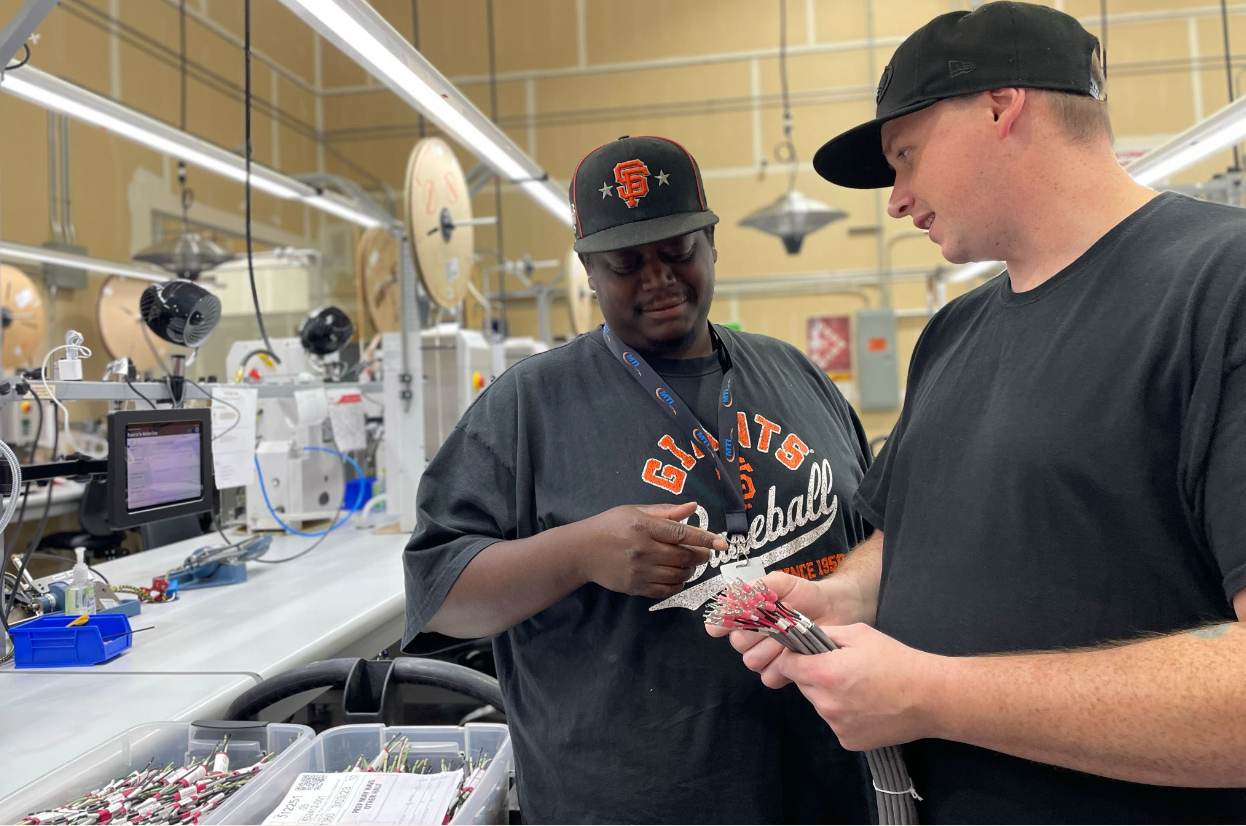 MTI employees discussing a batch of cables