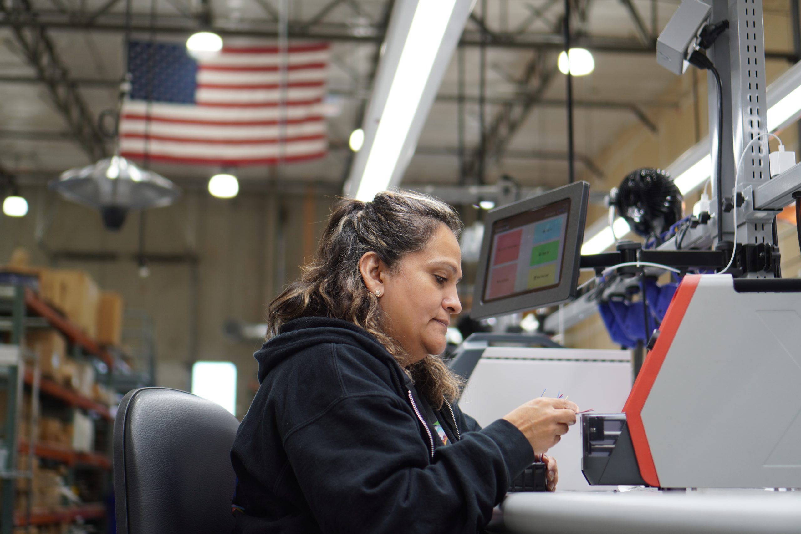 A female employee works at a wire processing station.